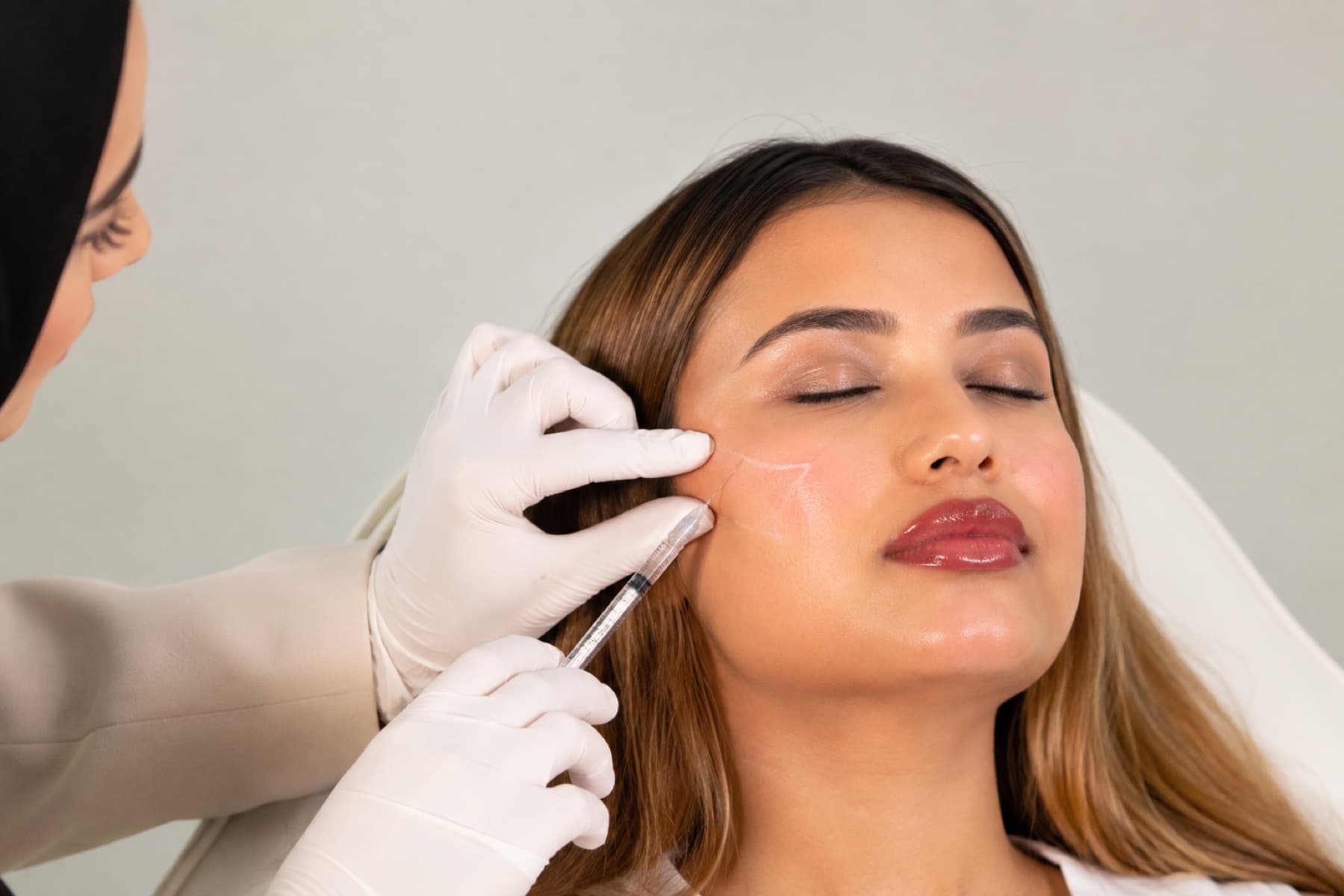 Practitioner administering cheek filler at House of Riri