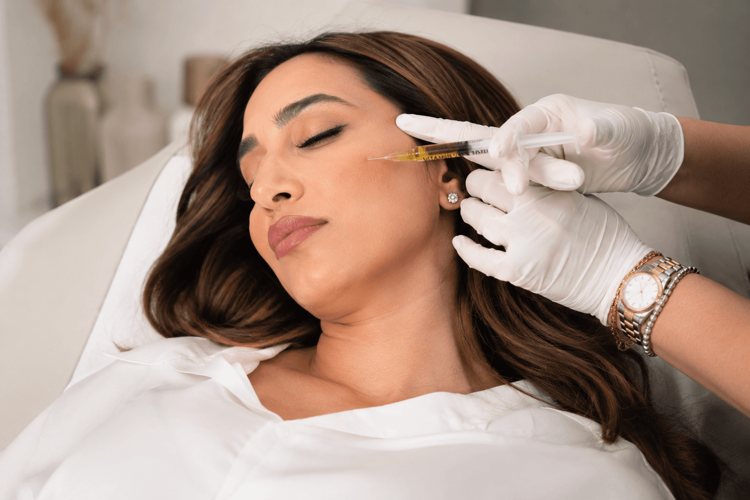 Preparing a skin booster injection at House of Riri: syringe and ampoule, gloved hands